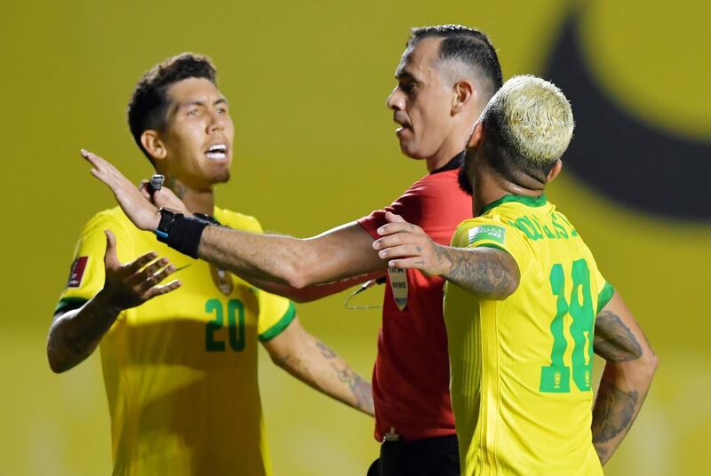 Brazil's Douglas Luiz and Roberto Firmino remonstrate with referee Nelson Almeida. Reuters