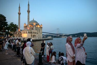 Tourists take selfies at the Bosphorus backdropped by the Ortakoy Mosque and the 15 July Martyrs Bridge in Istanbul, Turkey, 27 June 2021 (issued 29 June 2021).  Tourism has shrunk to near-zero in Turkey during pandemic times, heavily affecting the economy, but people hope the end of restrictions on 01 July will boost tourism again and bring relief to the sector.  Due to the pandemic, Turkey has recieved only 15 million visitors in 2020 compared to 45 million in 2019, but the end of restrictions on 1st July might allow to get back to at least 25 million in 2021 and stabilize the heavily affected tourism sector.   EPA / ERDEM SAHIN  ATTENTION: This Image is part of a PHOTO SET