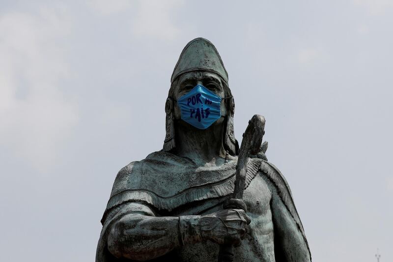 The monument of Tezozomoc is seen with a face mask that reads "For My Country" in Mexico City, Mexico. Reuters
