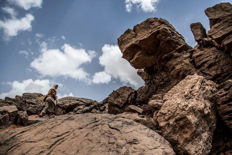 Ibrahim Musalam, a 28-year-old Egyptian Bedouin desert guide, ascends a cliff in the Abu Sour valley, near the coastal town of Abu Zenima in South Sinai governorate, on March 30, 2019. (Photo by Khaled DESOUKI / AFP)