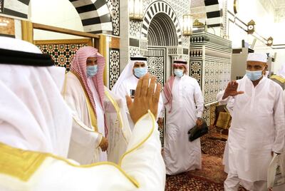 Men congratulate each other wearing masks and keep social distancing to help curb the spread of coronavirus outbreak after they perform Eid al Fitr prayers marking the end of the holy fasting month of Ramadan at al-Mirabi Mosque in Jiddah, Saudi Arabia, Thursday, May 13, 2021. (AP Photo/Amr Nabil)