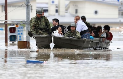 Japan Ground Self-Defense Force members use a boat to evacuate residents from a flooded area caused by heavy rains in Kurashiki, Okayama prefecture, southwestern Japan, Saturday, July 7, 2018. Torrents of rainfall and flooding continued to batter southwestern Japan. (Takumi Sato/Kyodo News via AP)