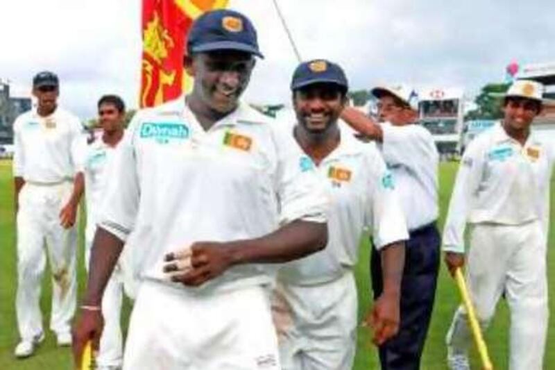 Sri Lankan cricketers Ajantha Mendis (C/L) and teammate Muttiah Muralitharan (C/R) walk off the ground with teammates at the conclusion of the Indian team second innings on the fourth day of the first Test match between India and Sri Lanka at The Sinhalese Sports Club (SSC) Ground in Colombo on July 26, 2008. Sri Lanka won by an innings and 239 runs with Muralitharan taking six wickets for 26 runs and Mendis taking four wickets for 60 runs.   AFP PHOTO/Lakruwan WANNIARACHCHI *** Local Caption ***  954612-01-08.jpg
