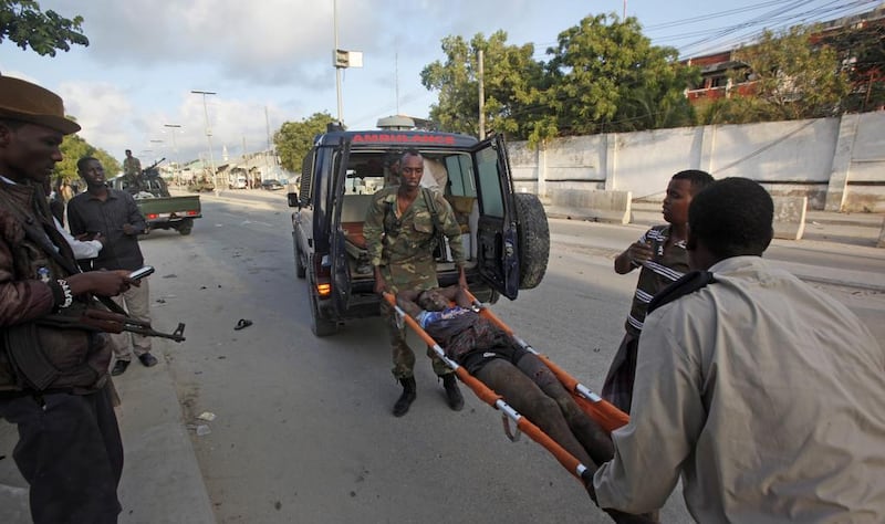 Somali policemen carry a wounded person to an ambulance outside the Sahafi Hotel in Mogadishu, Somalia, on November 1, 2015. Farah Abdi Warsameh / Associated Press