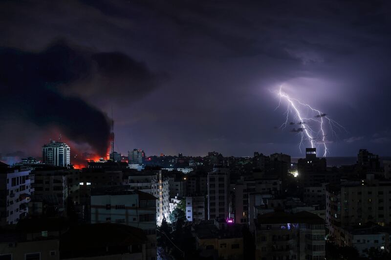 Lightning strikes as smoke billows following Israeli bombardment of Gaza City. AFP