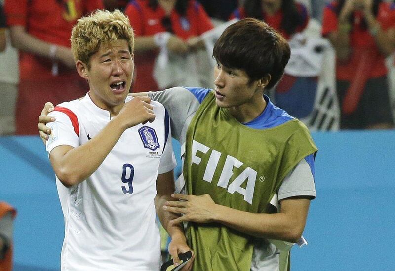 Son Heung-min, left, of South Korea is consoled by teammate Han Kook-young, right, after their elimination from the 2014 World Cup with a 1-0 loss to Belgium on Thursday night in Sao Paulo, Brazil. Lee Jin-man / AP
