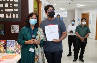 Sumanyu Tonapi receiving his IB results from Sunipa Neogi, IB co-ordinator at Gems Modern Academy. Pawan Singh / The National