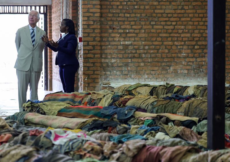 Manager Rachel Murekatete shows Prince Charles victims' clothes at the Nyamata Church Genocide Memorial in Kigala. PA