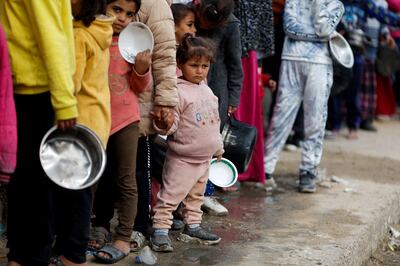 Palestinians stand in a line for food in Rafah, in southern Gaza, where 1.4 million people are displaced. Reuters 