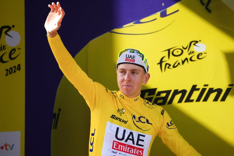 UAE Team Emirates' Tadej Pogacar celebrates on the podium in the overall leader's yellow jersey after Stage 2 of the Tour de France from Cesenatico to Bologna on Sunday, June 30, 2024. AP 