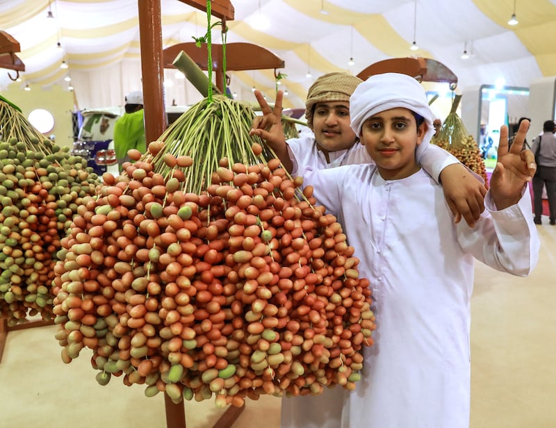 Abu Dhabi, U.A.E., July 18, 2018.  First day of the 2018 Liwa Date Festival. --   Boy's  check out the heaviest date fruit clumps of the festival.
Victor Besa / The National
Section:  NA
Reporter:  Haneen Dajani