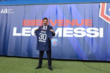 Paris Saint-Germain's Qatari President Nasser Al-Khelaifi (L) and Paris Saint-Germain's Sporting Director Leonardo Nascimento de Araujo (R) pose along side Argentinian football player Lionel Messi (C) as he holds-up his number 30 shirt during a press conference at the French football club Paris Saint-Germain's (PSG) Parc des Princes stadium in Paris on August 11, 2021. The 34-year-old superstar signed a two-year deal with PSG on August 10, 2021, with the option of an additional year, he will wear the number 30 in Paris, the number he had when he began his professional career at Spain's Barca football club.  (Photo by Mehdi Taamallah / NurPhoto via Getty Images)