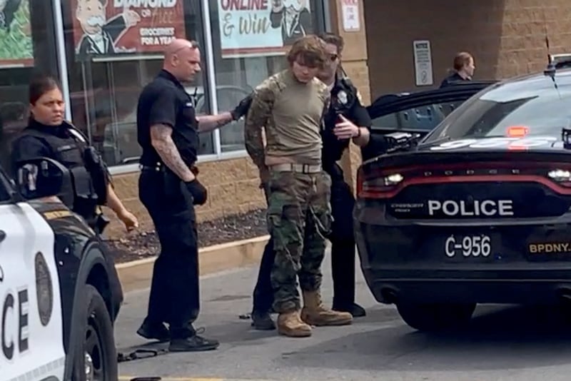 A man is detained after the mass shooting. Photo: BigDawg/ via Reuters