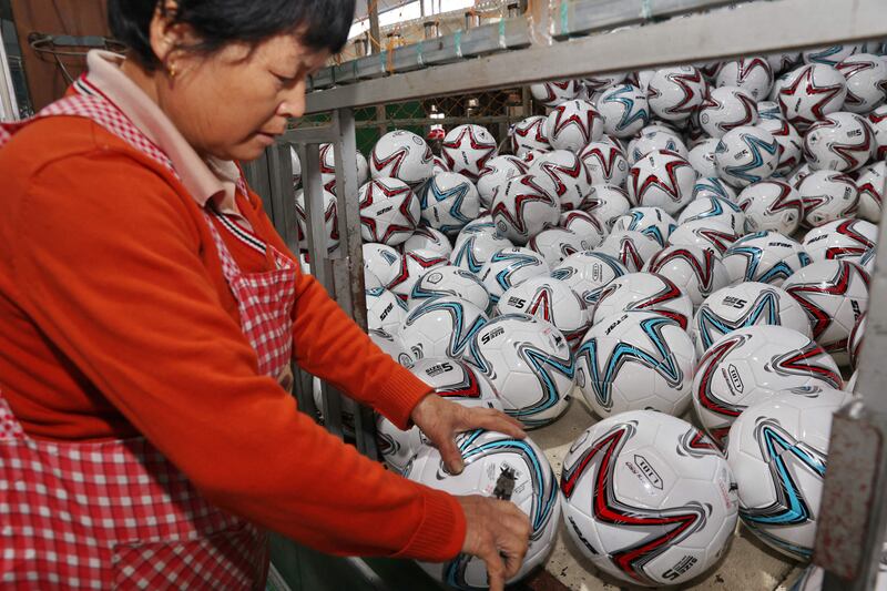 A worker checks footballs at a factory in Nantong in China's eastern Jiangsu province. AFP
