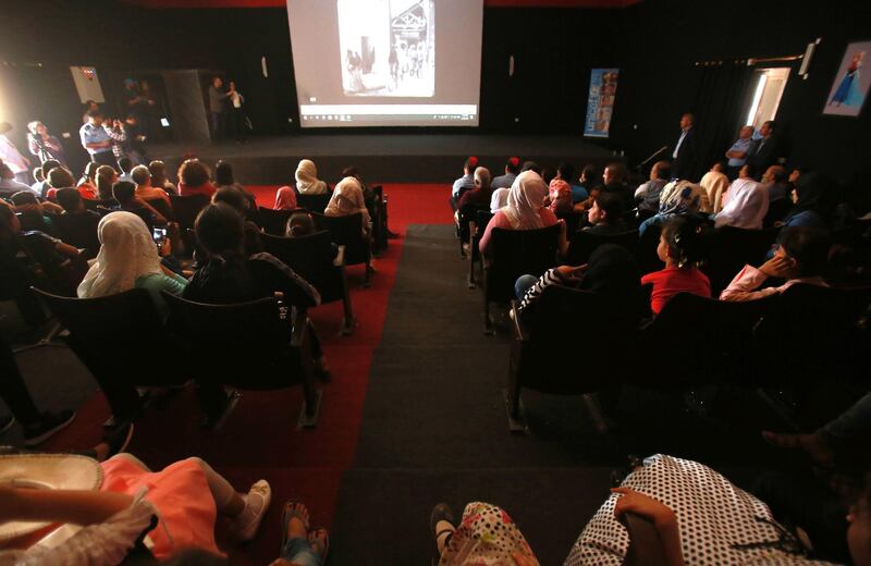 People watch the screening of a film at the Cinema Zaatari. AFP