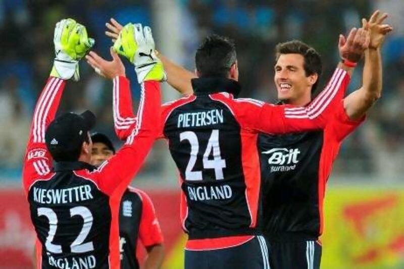 Steven Finn, right, celebrates with teammates after dismissing Mohammad Hafeez in Dubai on Saturday night. Finn also took the wickets of Umar Akmal and Umar Gul to end with figures of three for 30.