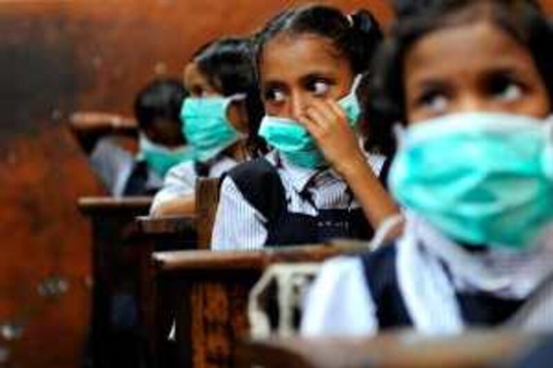 Indian school children, wearing protective masks distributed by the local right wing Shiv Sena party for an awareness campaign, are seen in a classroom in Mumbai on August 10, 2009. The number of people to die from swine flu in India rose to six, health officials said, as the government called for calm and people flocked to public hospitals for tests. The latest to die of the (A)H1N1 virus were an ayurvedic or traditional medicine practitioner in Pune, 120 kilometres (75 miles) from India's financial hub Mumbai, and a four-year-old boy in the southern city of Chennai.      TOPSHOTS/AFP PHOTO/ Pal PILLAI *** Local Caption ***  569770-01-08.jpg