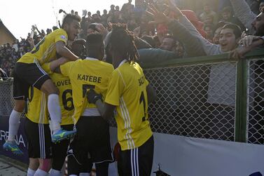 Real Kashmir's players celebrate a goal with their fans. AFP