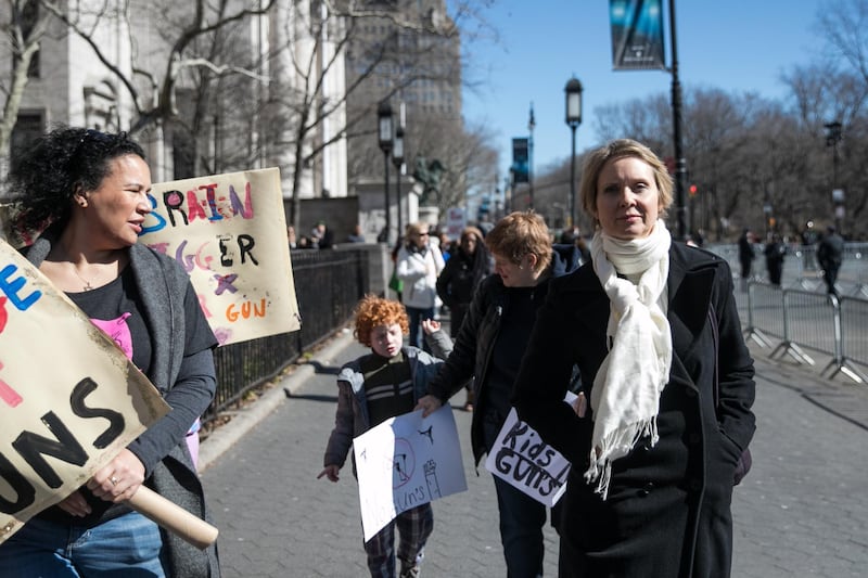 Cynthia Nixon, actress and 2018 New York gubernatorial Democratic candidate, right, walks on Central Park West ahead of the March For Our Lives in New York, U.S., on March 24, 2018. Thousands of high school students and other gun-control advocates gathered in Washington and across the U.S. Saturday to demand tougher firearms restrictions from an older generation that's delivered little change after years of mass shootings. Photographer: Jeenah Moon/Bloomberg