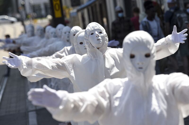 Performers wear white masks during a demonstration against new coronavirus safety measures in Nantes, western France.