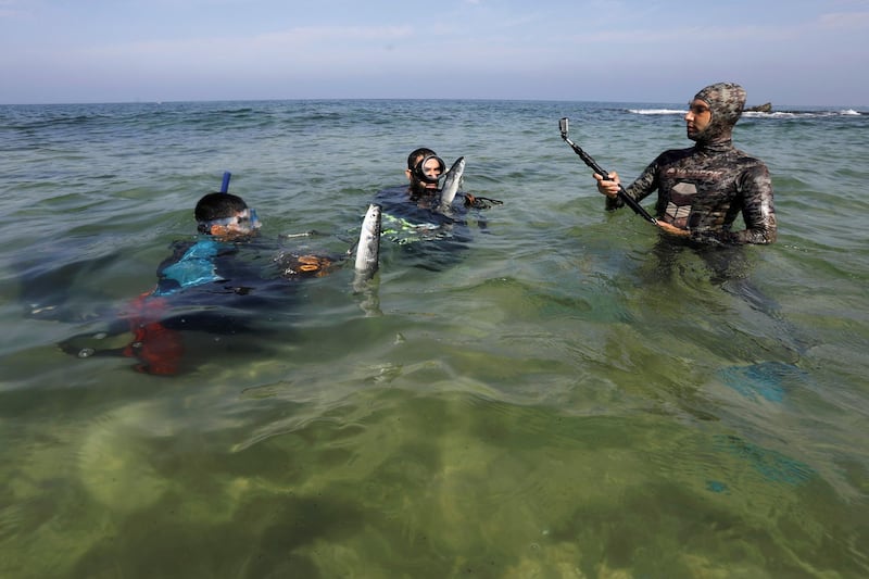 Palestinian spear-fishermen display fish at the Mediterranean Sea off the coast of the southern Gaza Strip.   Reuters