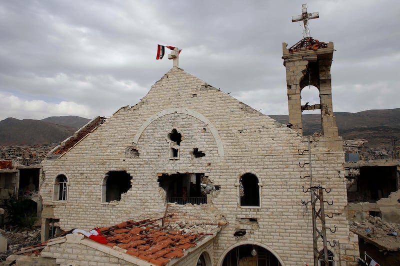 A Syrian flag raised over the damaged Saint Mary Roman Orthodox church at the mountain resort town of Zabadani in the Damascus countryside, Syria. The Qatar-based Syrian Network for Human Rights, a Syrian war monitor associated with the opposition said in its report that over 120 Christian places of worship have been damaged or destroyed by all sides in the country’s eight-year conflict.  AP