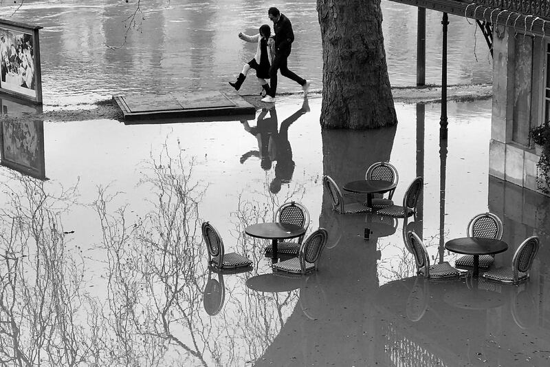 Pedestrians walk along the Seine river in the Chatou suburb of Paris, France in this black and white image. Water levels continue to rise after weeks of heavy rain in France. Pascal Le Segretain / Getty Images