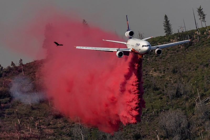 An aircraft drops flame retardant to control the fire. Reuters