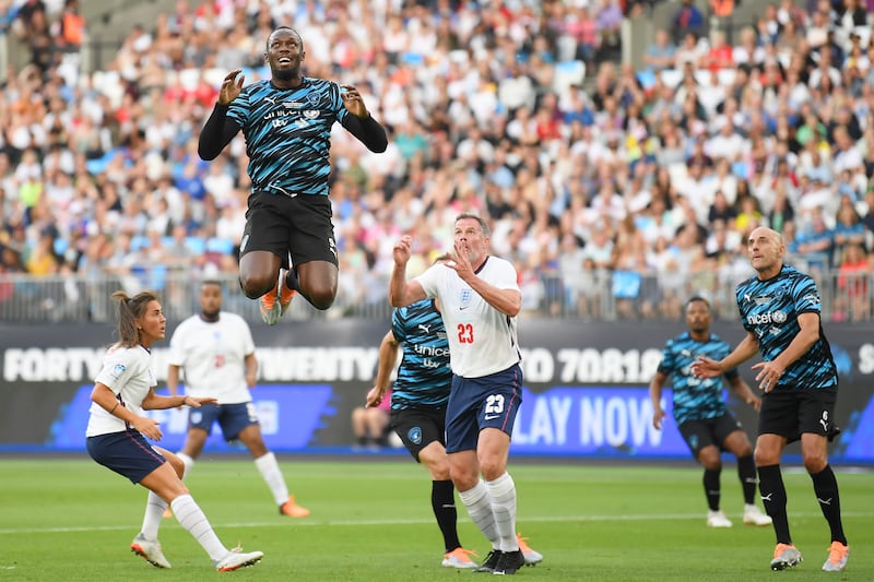 Usain Bolt of Team World XI jumps for the ball. Getty Images