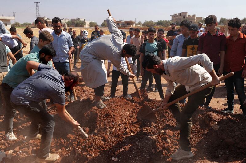 Mourners bury the four siblings at a graveyard in the Syrian town of Binnish on Monday. AFP