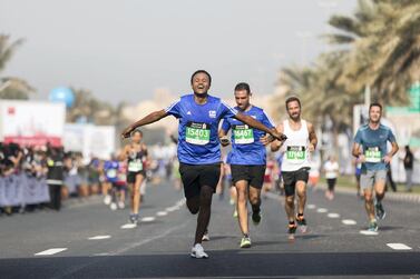 Runners arriving at the finish line at the Standard Chartered Dubai Marathon. The National