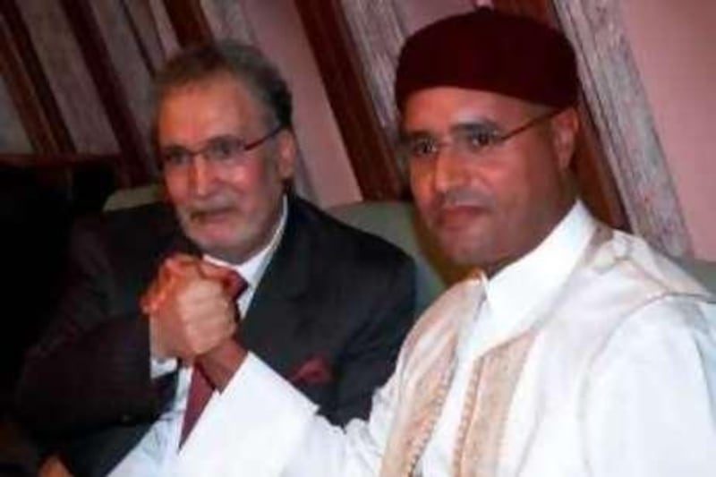Libyan leader Moamer Kadhafi's son Seif al-Islam (R) holds hands with freed Lockerbie bomber Abdelbaset Ali Mohmet al-Megrahi, the sole Libyan convicted over the 1988 Pan Am jetliner bombing, aboard the Libyan presidential plane that brought him back home in Tripoli late on August 20, 2009. The Libyan leader met in late on August 21 with Megrahi, who is suffering from terminal prostate cancer, amid mounting Western outrage over the hero's welcome he received upon his return. According to local media, Seif al-Islam said Megrahi's release from a Scottish prison was linked to trade deals with Britain, allegations which were swiftly denied by London.   AFP PHOTO/STR