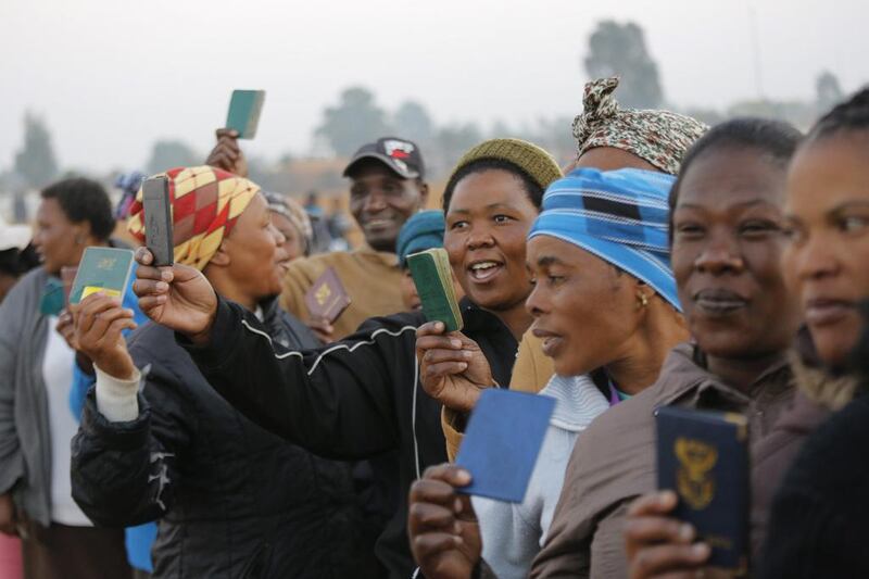 South Africans show their ID cards as they stand in line at a polling station. About 25 million people were eligible to vote in the elections. Kim Ludbrook / EPA