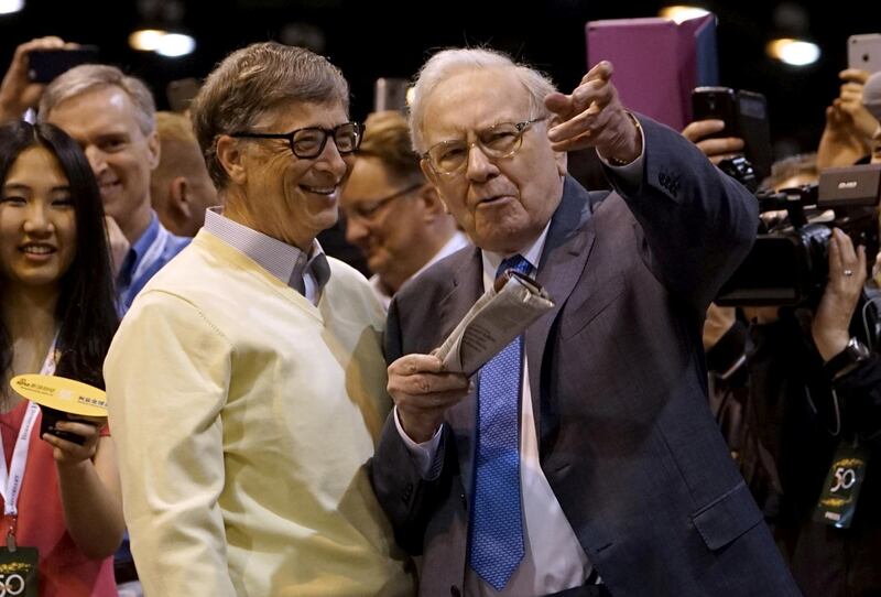 FILE PHOTO: Berkshire Hathaway CEO Warren Buffett (R) shows his friend Microsoft co-founder Bill Gates the finer points of newspaper tossing, prior to the Berkshire annual meeting in Omaha, Nebraska May 2, 2015.  REUTERS/Rick Wilking/File Photo