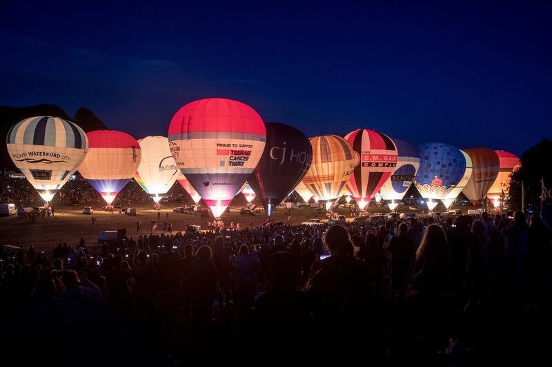 Crowds watch as tethered balloons are illuminated. Getty Images