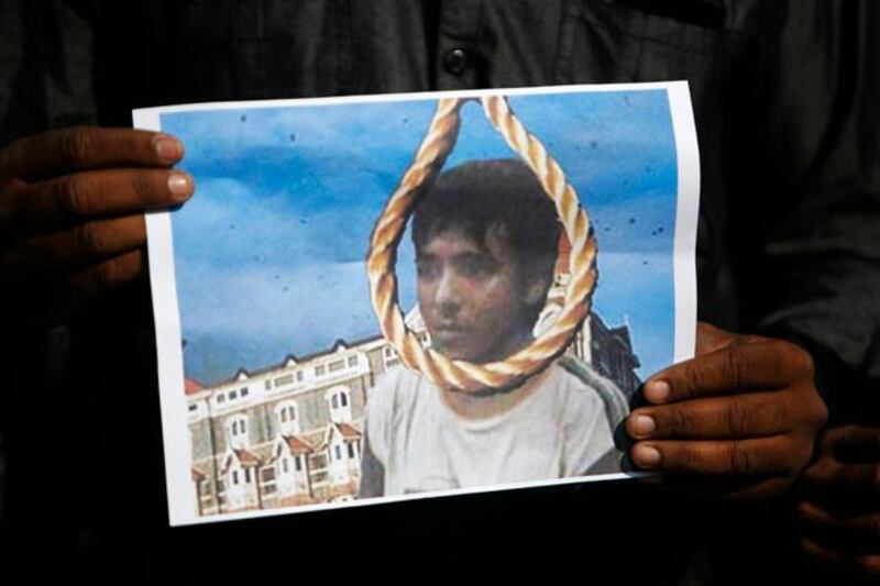 A man holds a picture of Mohammad Ajmal Kasab with a noose, as he celebrates Kasab's execution, in the western Indian city of Ahmedabad November 21, 2012. India executed Kasab, the lone survivor of a militant squad that killed 166 people in a rampage through the financial capital Mumbai in 2008, hanging him on Wednesday just days before the fourth anniversary of the attack. REUTERS/Amit Dave (INDIA - Tags: CRIME LAW CIVIL UNREST)