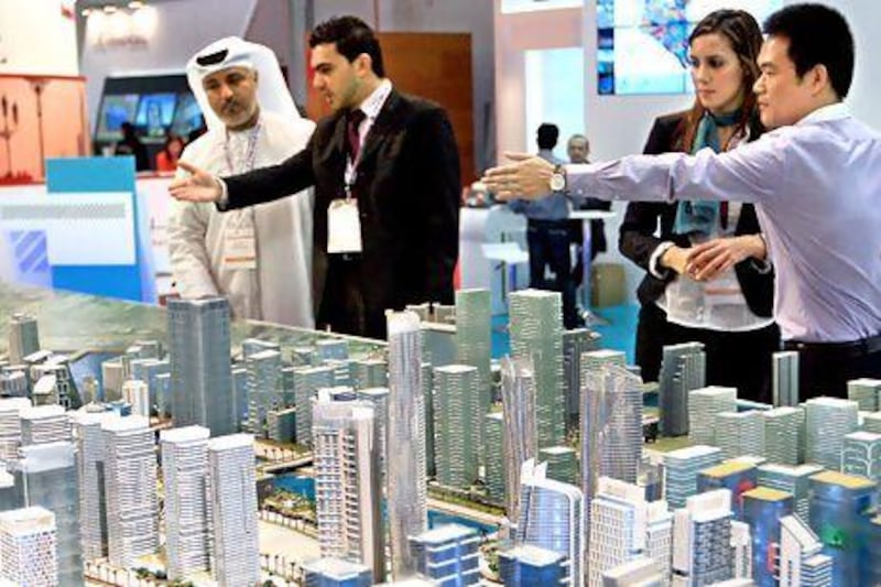 Cityscape visitors look at a model of Reem Island. Growing supply should further push down residential rents in the capital. Ravindranath K / The National