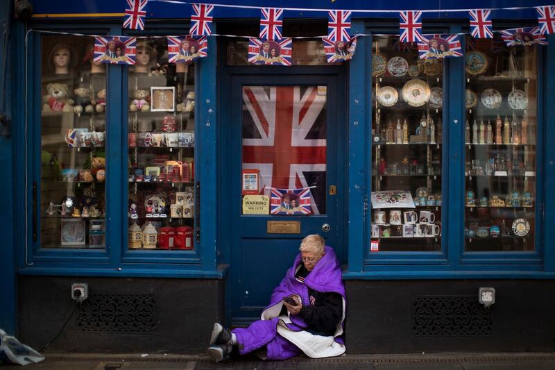 A woman sits at the door of a closed souvenir shop. Emilio Morenatti / AP Photo