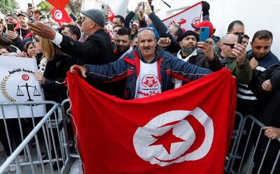 Supporters of Tunisian President Kais Saied carry national flags and banners during a protest against the Supreme Judicial Council, in Tunis on Sunday. Photo: Zoubeir Souissi / Reuters