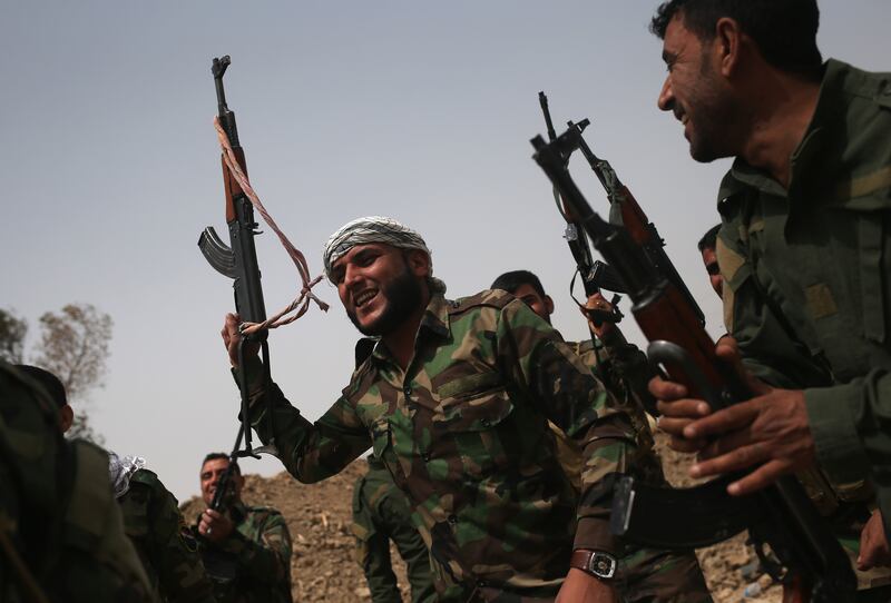 Volunteers from the Badr Brigade cheer after an exchange of fire with ISIS fighters on the front line in Ebrahim Ben Ali, Iraq in 2015. Getty Images