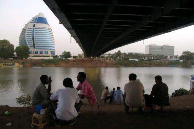 Sudanese drink tea by the Nile under a bridge leading to the Burj Al-Fateh hotel. AFP