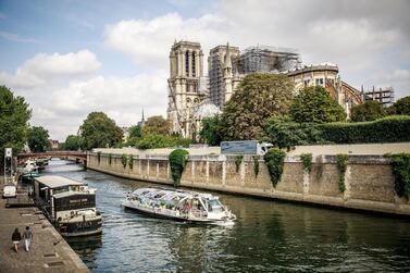 A touristic boat cruises in front of the Notre-Dame Cathedral in Paris, on August 7, 2019. The yard has been stopped since analyses proving an excessive presence of lead and the risks taken by the workers three months after the Cathedral was badly damaged by a huge fire last April. EPA