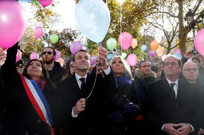 French President Emmanuel Macron (2ndL), his wife Brigitte Macron (C), Paris Mayor Anne Hidalgo (L) and former French President Francois Hollande (R) release balloons at Paris 11th district town hall, France, November 13, 2017, during a ceremony held for the victims of the Paris attacks which targeted the Bataclan concert hall as well as a series of bars and killed 130 people. REUTERS/Philippe Wojazer