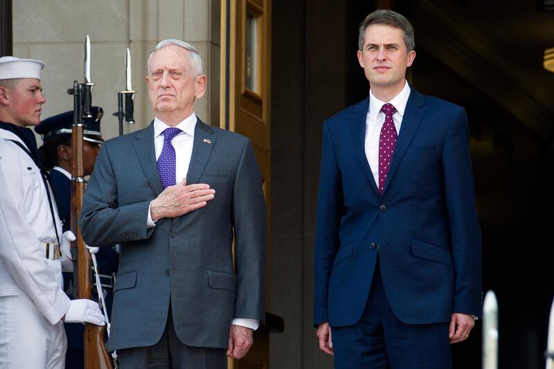 Secretary of Defense Jim Mattis, left, and UK Secretary of State for Defense Gavin Williamson stand for the National Anthem during a welcome ceremony prior to their meetings at the Pentagon, Tuesday, Aug. 7, 2018. (AP Photo/Cliff Owen)