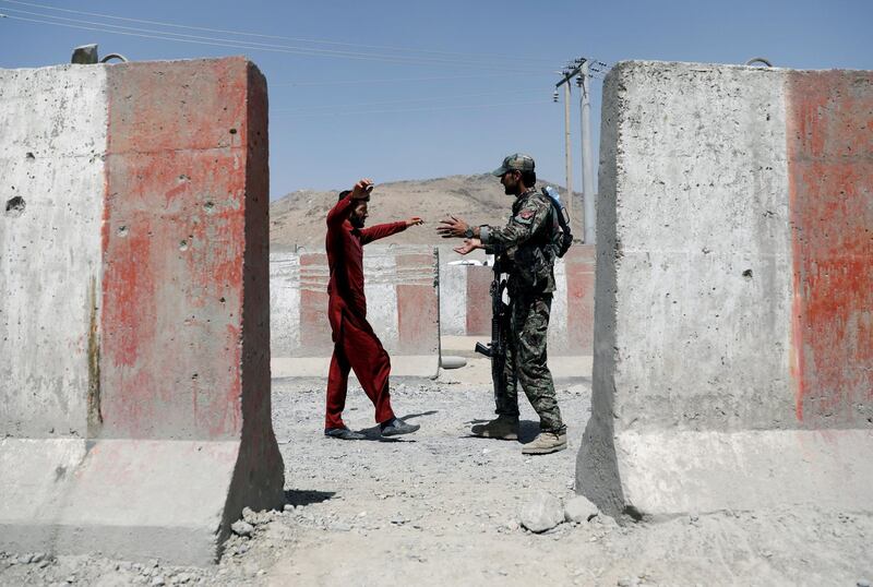 An Afghan National Army  soldier inspects a passenger's credentials at a checkpoint on the Ghazni to Kabul motorway. Reuters