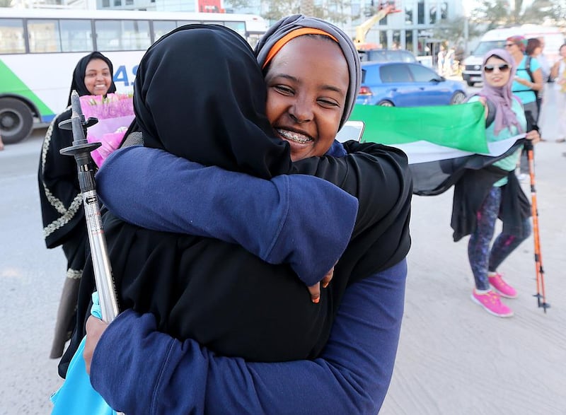 Nima Abdi is greeted by a family member at the Zayed Centre after finishing the Heritage walk. Satish Kumar / The National