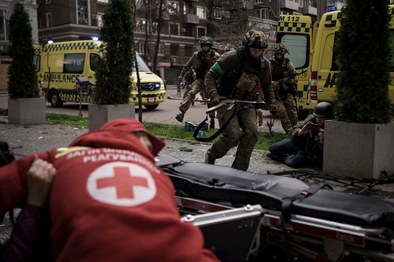 Ukrainian servicemen run for cover as explosions are heard during a Russian attack in Kharkiv. AP