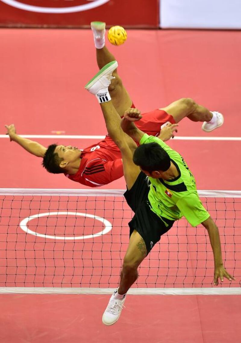 Indonesia's Nofrizal, left, strikes the ball against Myanmar's Zaw Aung Zaw in the men's doubles group sepaktakraw match at the 2014 Asian Games. Jung Yeon-je / AFP