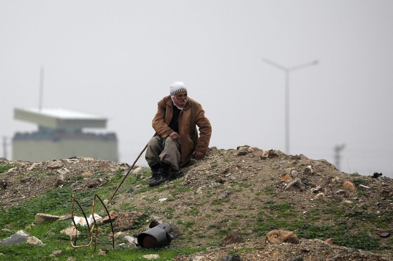 An elderly man sits near the Syrian-Turkish border in Ras al-Ayn town, Syria. Reuters