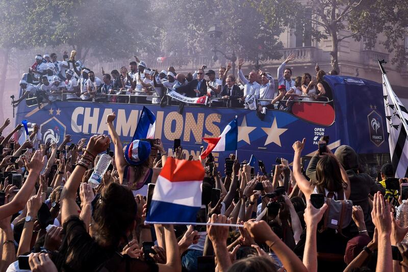 TOPSHOT - France's national football team players celebrate on the roof of a bus as they parade down the Champs-Elysee avenue in Paris, on July 16, 2018 after winning the Russia 2018 World Cup final football match. / AFP / Lucas Barioulet
